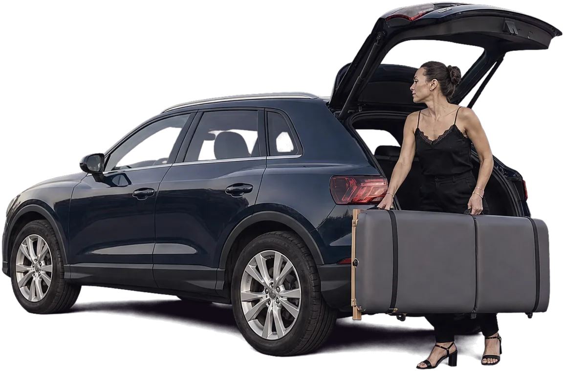 Hélène sort la table de pose pliée du coffre de sa voiture