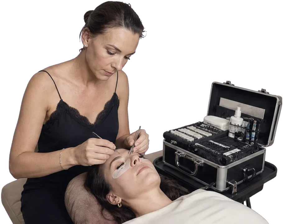 Hélène pose les extensions cil à cil, patchs en place et mallette ouverte à côté d'elle